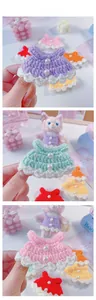 Detail of handmade crochet doll dress with pearl accents and delicate wavy white lace hem
