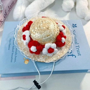 Detailed macro view of pet straw hat with crochet flowers, lace trim and adjustable drawstring