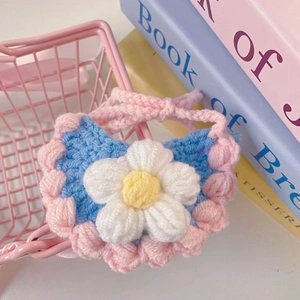 Close-up of handmade crochet pet bib with floral decor and pink woven straps