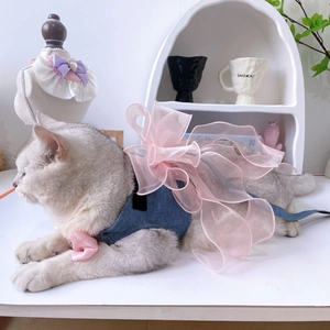 Close-up of blue denim cat harness featuring a large pink organza bow and collar tie