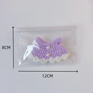 Purple knitted doll dress with pearl accents and scalloped white lace trim, 12x8cm size