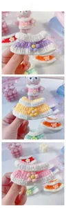 Detailed macro view of handmade colorful knitted doll dresses with floral embroidery