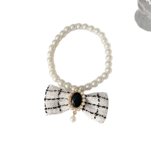 Elegant white pearl pet necklace featuring a black and white tweed bow and pendant