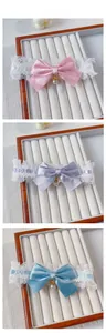 Detailed close-up of lace leg garters with satin bows and pearls in pink, purple, and blue