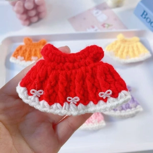 Close-up of handmade crochet doll dress with white fur trim and pearl bow details
