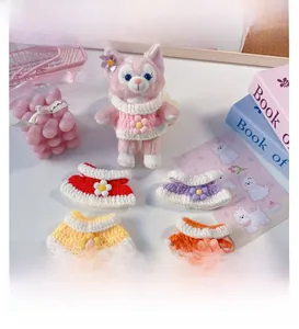 Close-up of handmade crochet flower collars and knitted outfits for 15cm plush dolls