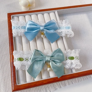 Detail of pet lace collars with ribbon bows and pearls in a velvet jewelry box