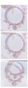 Detailed shot of iridescent gradient pearl pet necklace with heart and cat pendants