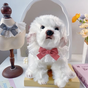 Detail of cute white plush dog wearing a delicate white lace collar with a red plaid bow