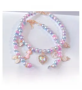 Detailed view of colorful iridescent pearl pet necklace with heart and moon pendants