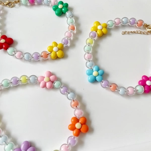 Gros plan de colliers colorés pour animaux avec pendentifs fleurs et fermoirs réglables