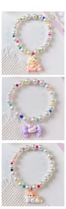 Detail of beaded pet necklaces featuring white pearls and cartoon resin animal charms