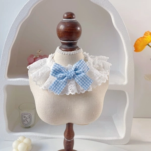 Cute pet lace collar with blue checkered bow on wooden mannequin for small cats and dogs