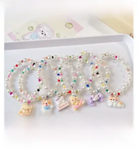 Detail of colorful pet pearl necklaces with cute resin cartoon pendants in a display tray