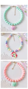 Close-up of candy-colored beaded pet necklaces with heart and rainbow pendants