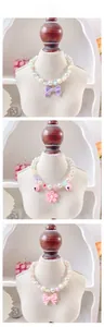 Detailed tile display of pearl pet necklaces with floral bells and ribbon bows