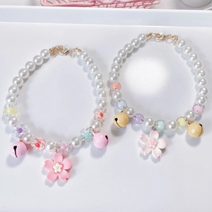 Detail of pet pearl collars with pink cherry blossom pendants and metal lobster clasps