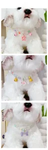 Detail of pet pearl collars with colorful bells and flower charms on white plush model