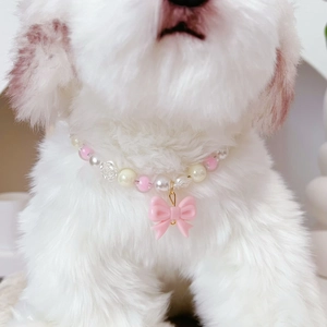 Close-up of pink and white pearl pet necklace with rose beads and a bow pendant