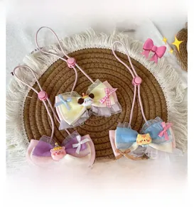Close-up of three handmade cartoon pet bow ties with lace edges and cute animal charms