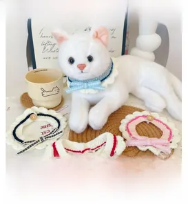 Detail of hand-knitted pet collars with plaid bows and buttons for cats and dogs