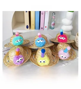 Macro shot of colorful handmade straw pet hats with plush monster eyes and elastic straps