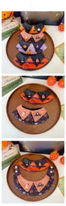Detail of Halloween pet bibs featuring pumpkin and bat motifs with secure snap fasteners