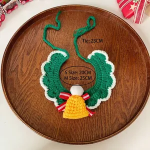 Christmas cat knitted green collar with yellow bell and festive red bow on wooden tray