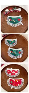 Close-up of festive lace pet bibs with Christmas patterns on wooden tray