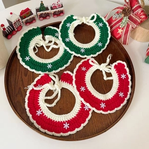 Handmade Christmas pet collars with knitted snowflakes for cats and dogs on wooden tray