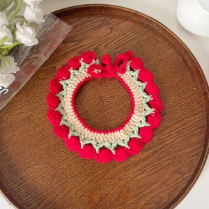 Close-up of red crochet flower pet collar on a wooden tray for Christmas gift