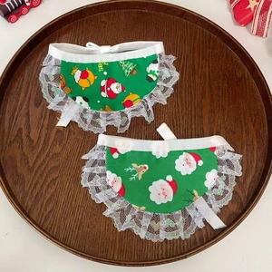 Detailed top view of green Christmas pet bibs with lace trim on a wooden tray