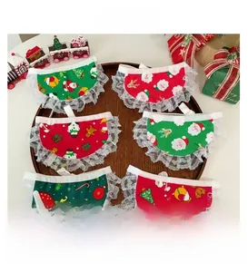 Detail of Christmas pet bibs with lace trim and festive prints on a wooden tray
