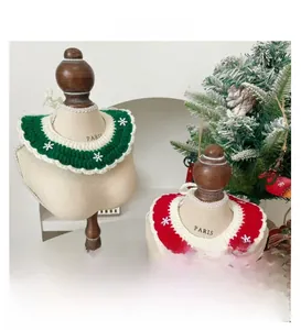 Close-up of handmade red and green knitted Christmas pet scarves with snowflake patterns
