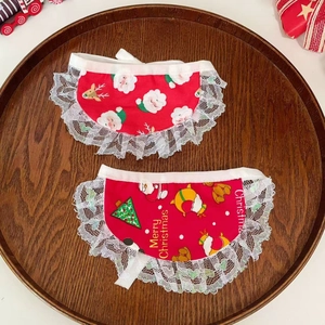 Two-pack Christmas pet bibs with Santa print and white lace trim on a wooden tray