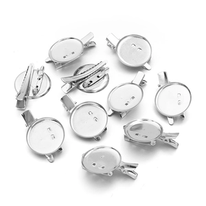 Detailweergave van zilveren metalen ronde dienbladbases met haarklemmen en brochespelden