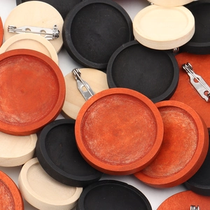 Detail van ronde houten broche-bases met roestvrijstalen spelden voor DIY-sieraden maken