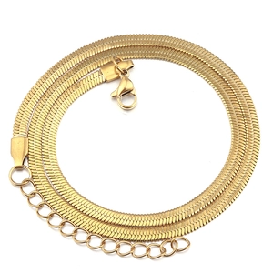Detail of golden stainless steel flat snake chain with lobster clasp and extender