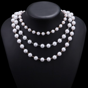 Detalle de collares de perlas blancas de tres capas 8-10mm sobre un busto de joyería negro