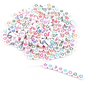 Macro shot of 7x4mm acrylic letter beads with colorful stars and heart patterns