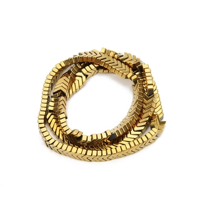 Macro shot of vacuum plated gold hematite beads in arrow and rectangle shapes for jewelry