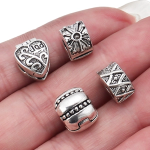Macro shot of antique silver heart and sun pattern charms for DIY jewelry making