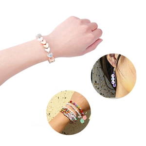 Detail van CCB-hartkralen en kleurrijke bedelarmbanden met alfabetische elementen