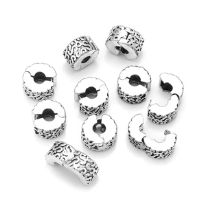 Macro shot of oxidized silver spacer beads with intricate floral engravings for DIY jewelry