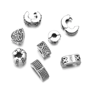 Detailed close-up of antique silver stopper beads with floral and heart carvings for DIY jewelry