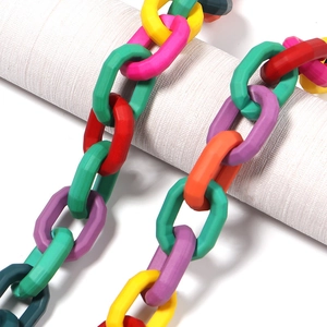 Primer plano de eslabones de cadena de acrílico coloridos sobre un soporte blanco