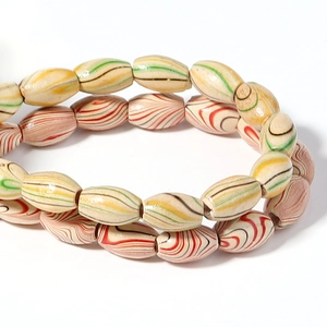Macro shot of oval bohemian beads with colorful spiral patterns and retro wooden texture