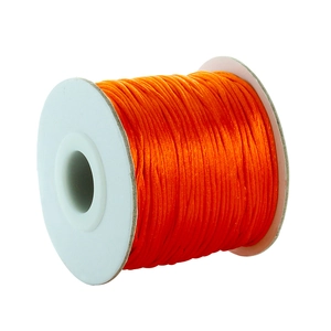 Macro detail of glossy orange satin cord roll for DIY jewelry weaving and crafts