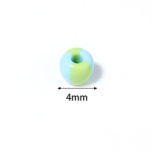 Dettaglio macro di una perla di vetro vintage da 4mm con strisce blu e verde chiaro