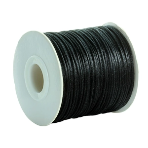 Macro detail of glossy black nylon cord on a spool for DIY jewelry and knot making